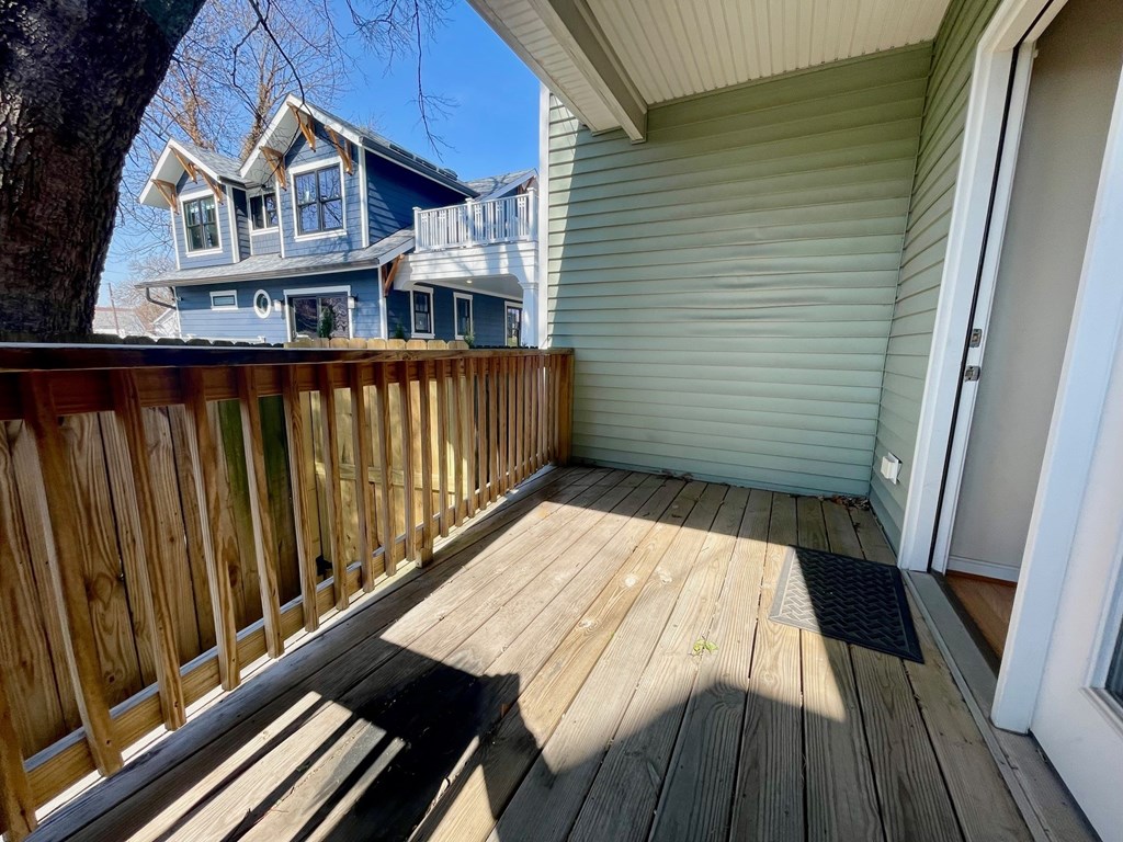 A wooden deck with a house in the background.