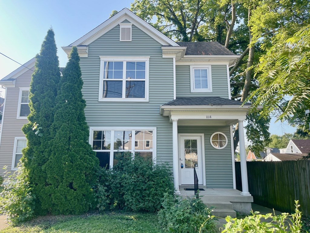 A house with a grey exterior and a white door.