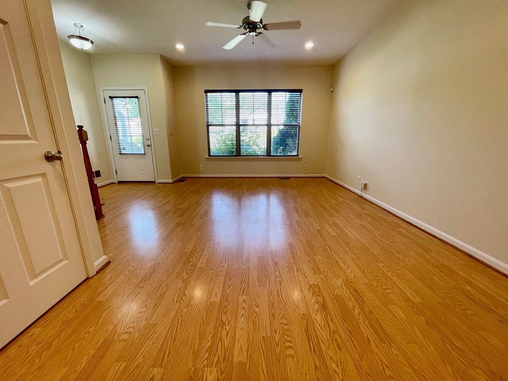 A room with wooden flooring and a ceiling fan.