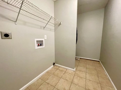 A small closet with a shelf and a door.