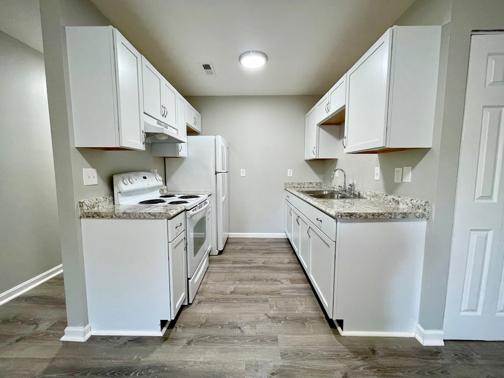 A kitchen with white appliances and cabinets.