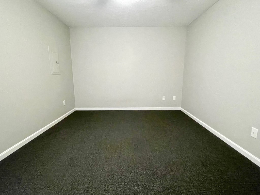 A room with a carpeted floor and white walls.