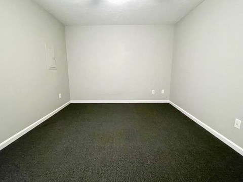 A room with a carpeted floor and white walls.
