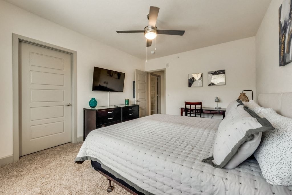 a bedroom with a bed and a ceiling fan