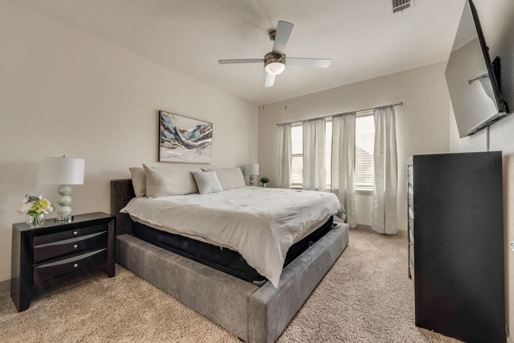 a bedroom with a bed and a ceiling fan