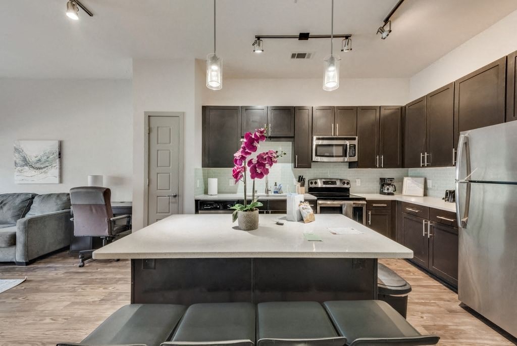 a kitchen and living room with a white counter top