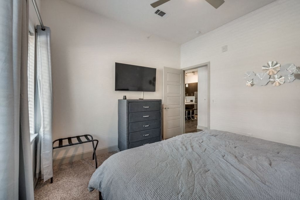 a bedroom with a bed and a tv on the wall