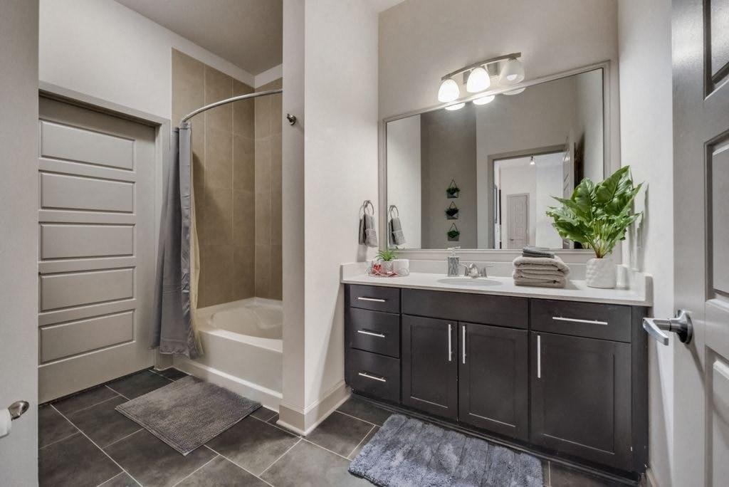 a bathroom with a shower and a sink and a mirror