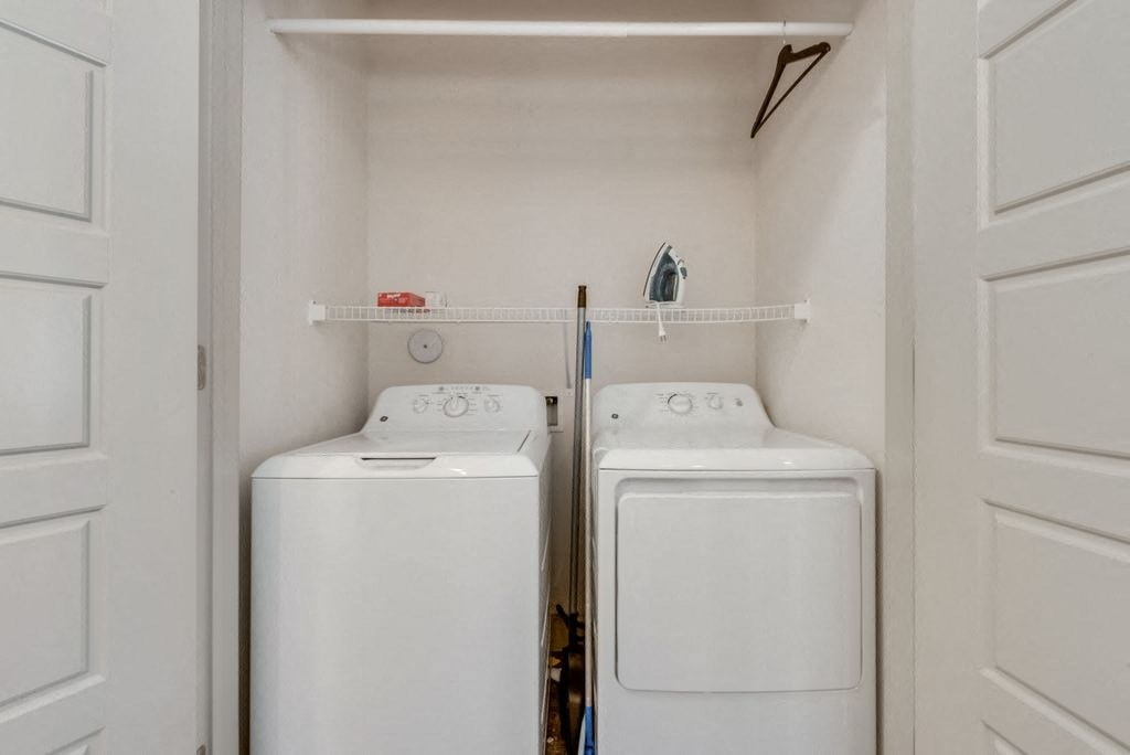 two white washers and dryers in a laundry room with white doors