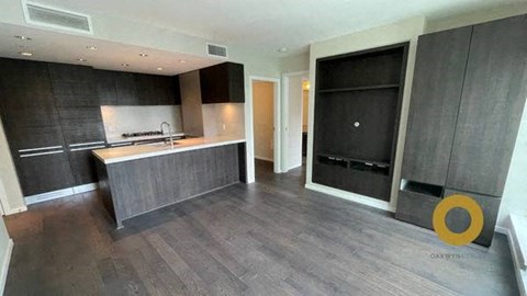 A modern kitchen with dark wood floors and a black oven.