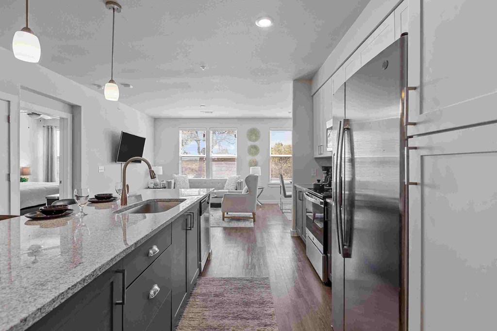 a large kitchen with stainless steel appliances and a long counter top