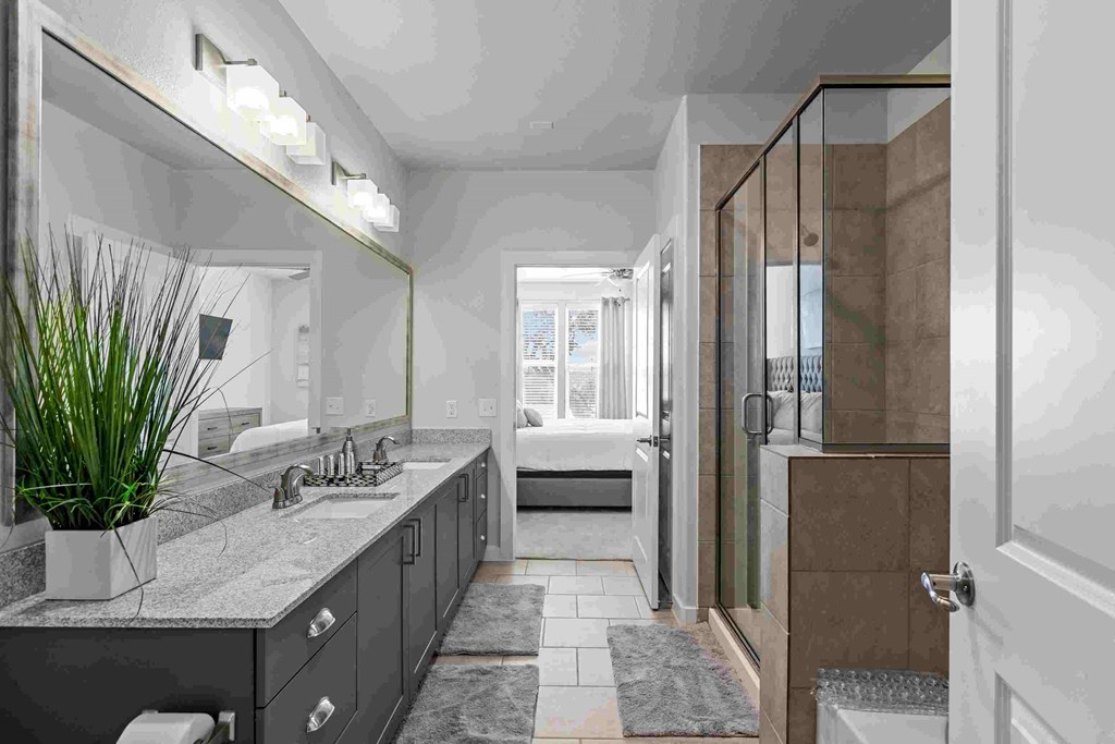 a bathroom with a shower and a sink and a mirror