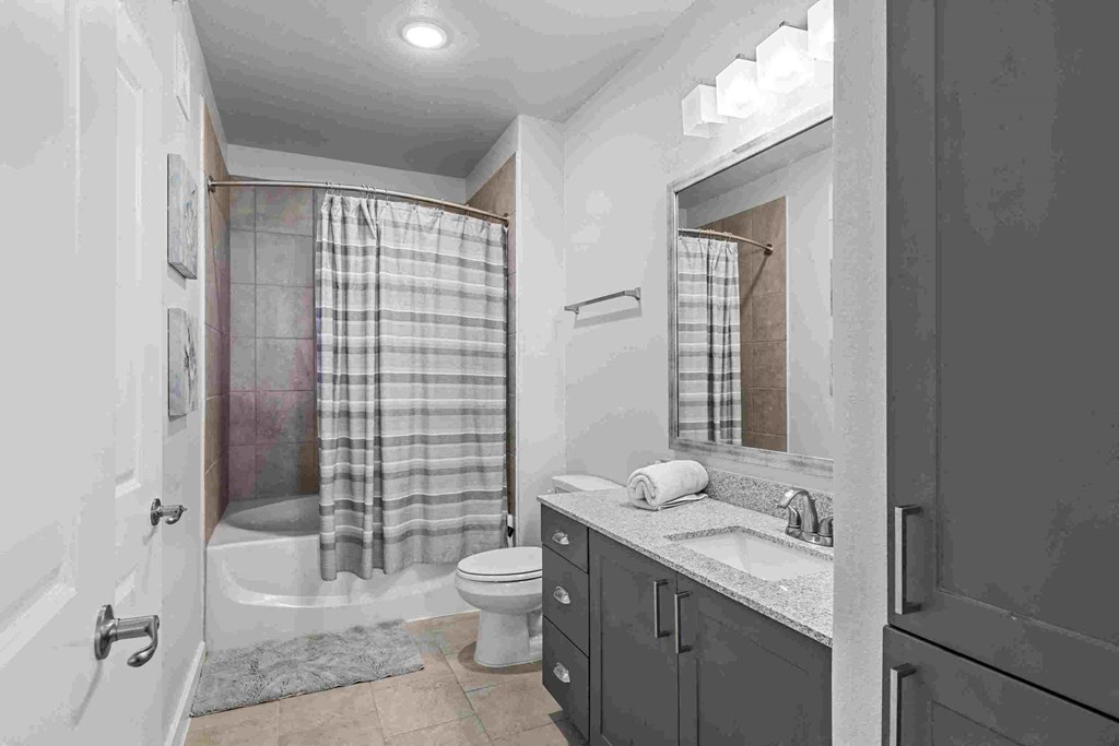 a bathroom with a shower and a sink and a toilet