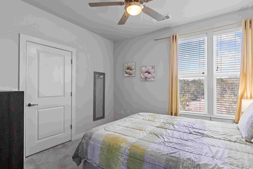 a bedroom with a bed and a ceiling fan