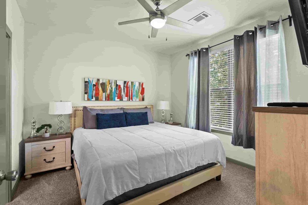 a bedroom with a bed and a ceiling fan