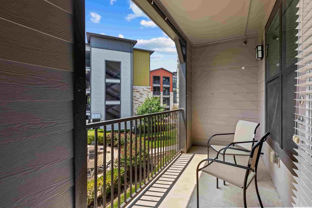 a patio with a chair on the balcony of a house