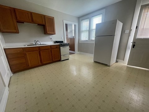 an empty kitchen with a refrigerator and a sink