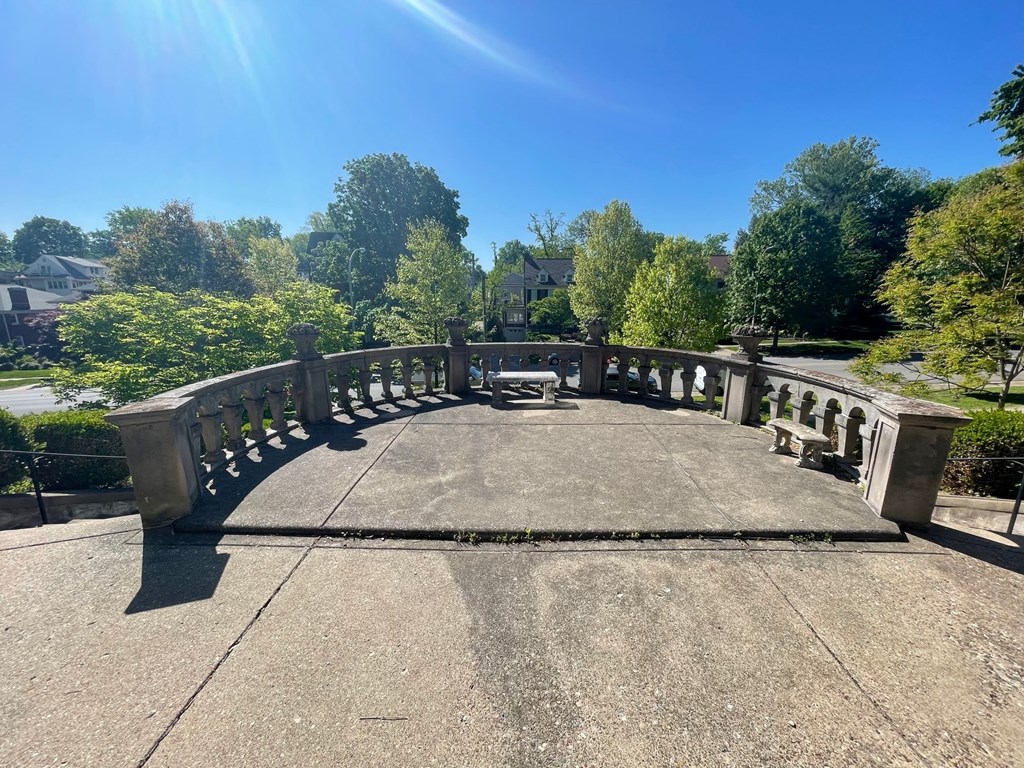 a stone bridge with trees in the background and a blue sky