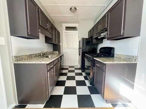 a kitchen with black and white checkered floor and stainless steel appliances