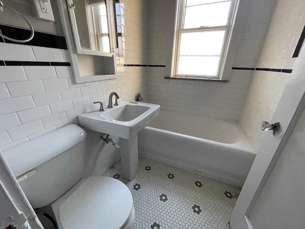 a bathroom with a sink toilet and a bath tub