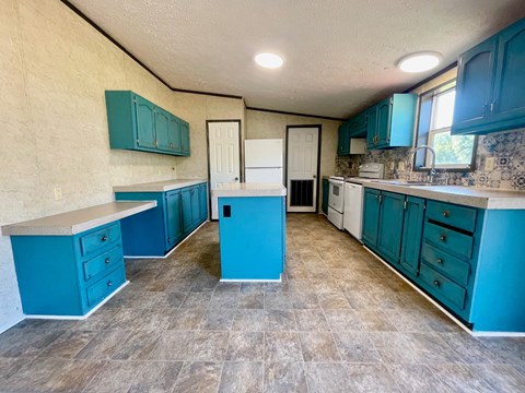 A kitchen with blue cabinets and a tile floor.