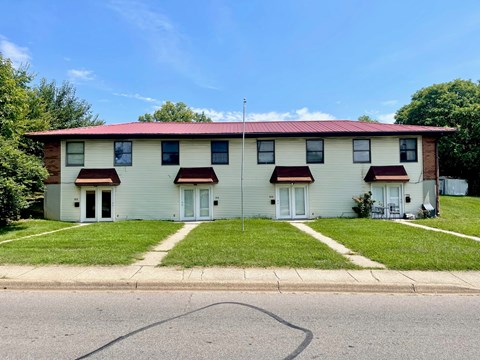 A two-story house with a red roof and white siding.