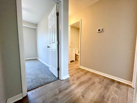 a bedroom with a door open to a hallway and a door to a bathroom