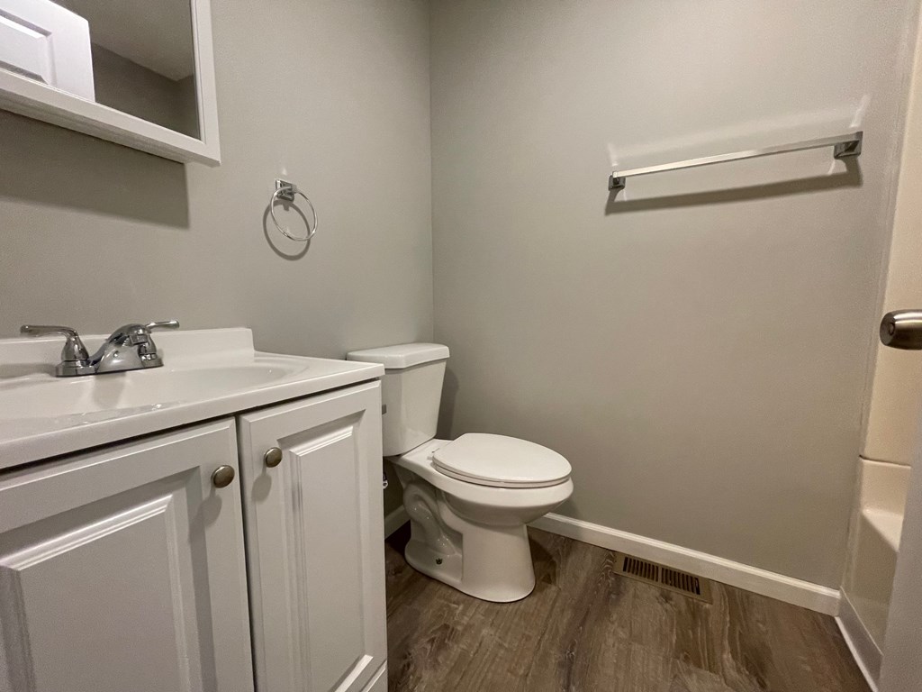 A white toilet sits next to a sink in a small bathroom.