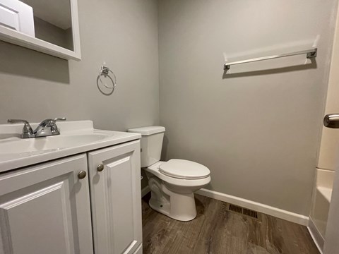 A white toilet sits next to a sink in a small bathroom.