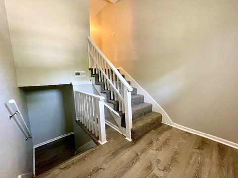 A staircase with a white railing and wooden steps.