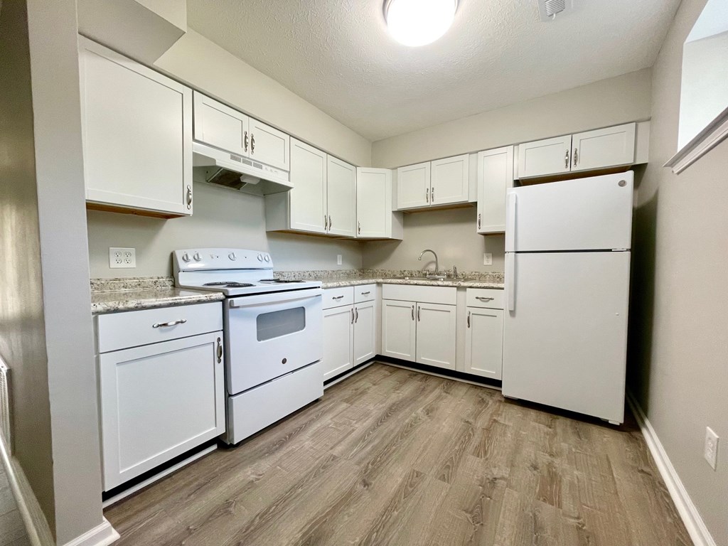 A kitchen with white appliances and cabinets.