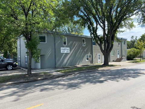 a gray building with trees in front of it