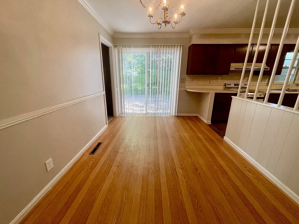 A room with wooden floors and a chandelier.