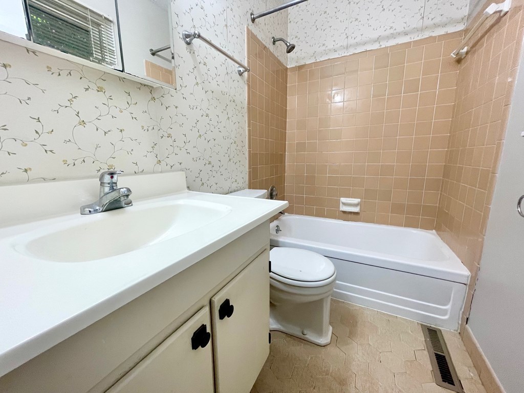 A bathroom with a sink, toilet, and bathtub.