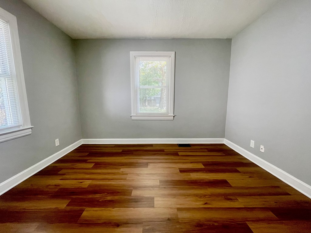 A room with wooden flooring and a window.