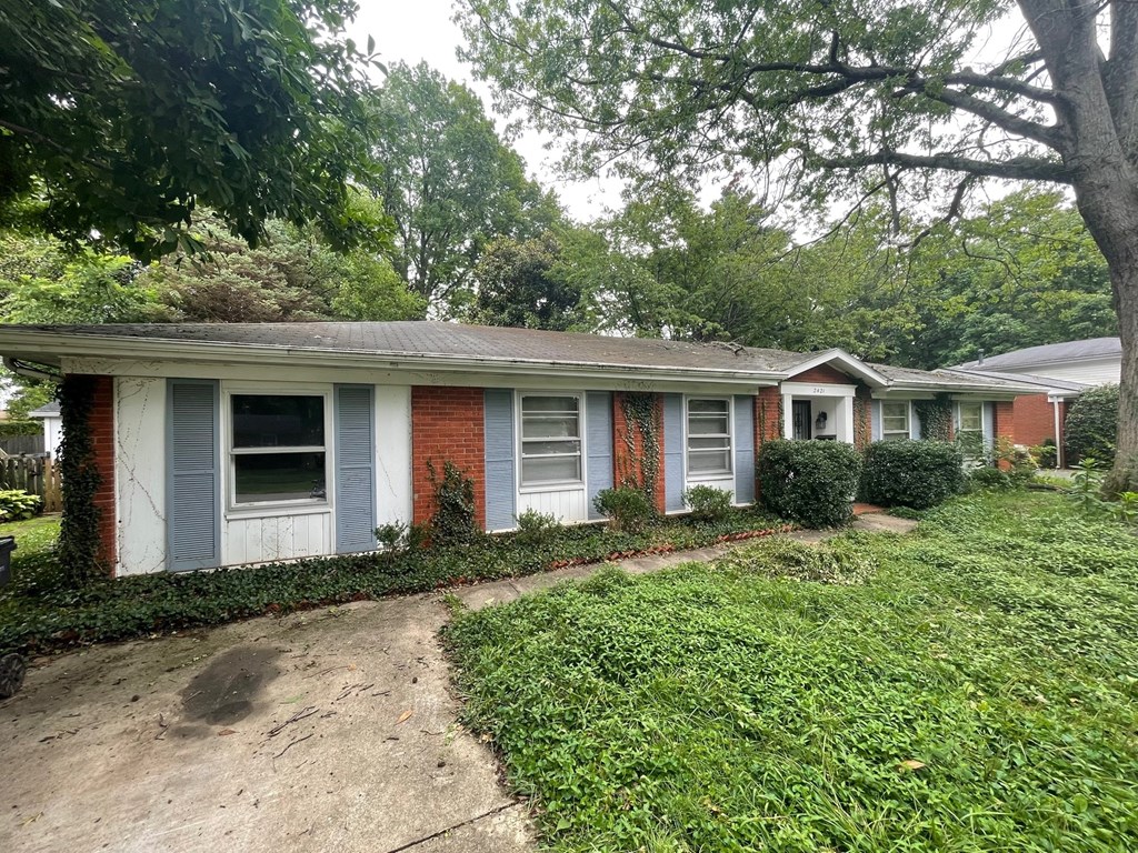A red and white house with a green lawn in front.