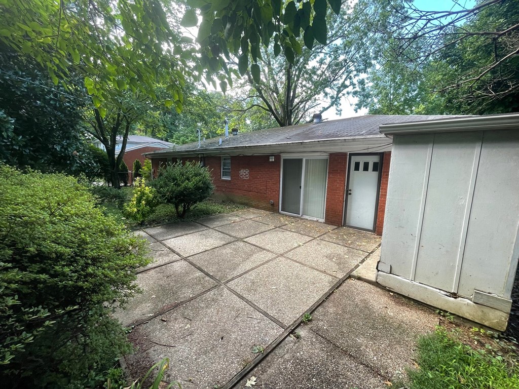 A red brick house with a white garage door and a concrete driveway.