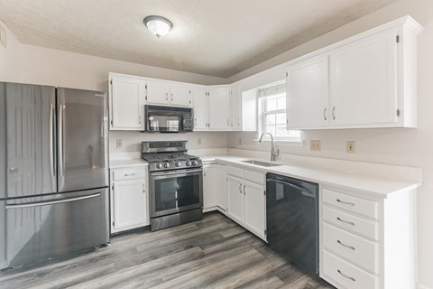 a white kitchen with stainless steel appliances and white cabinets