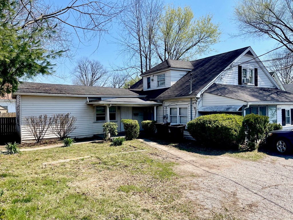a white house with a yard and a black roof
