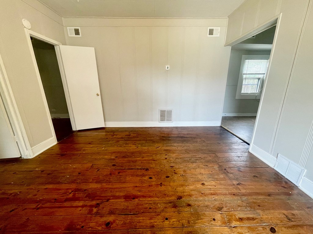 an empty room with white walls and a wooden floor