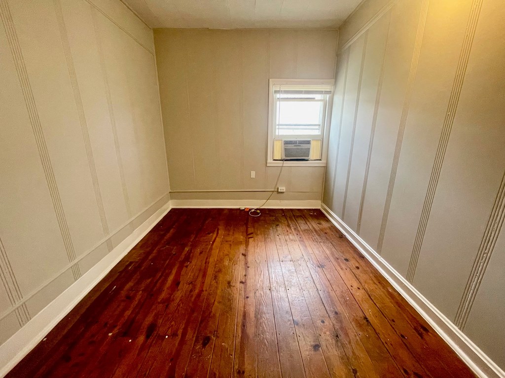 a small room with wooden floors and a window