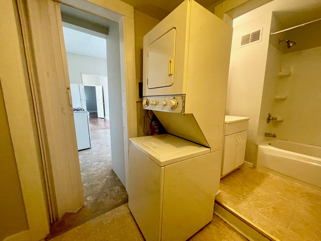 a laundry room with a washer and dryer and a bathroom with a sink