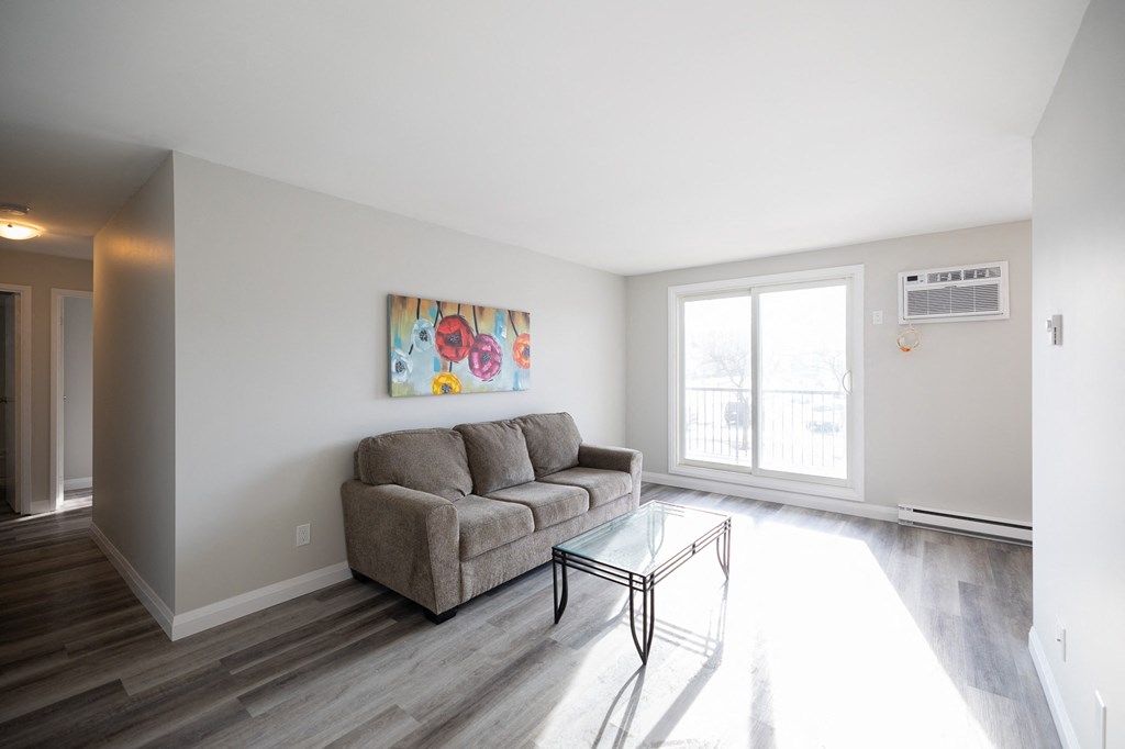 an empty living room with a couch and a glass coffee table