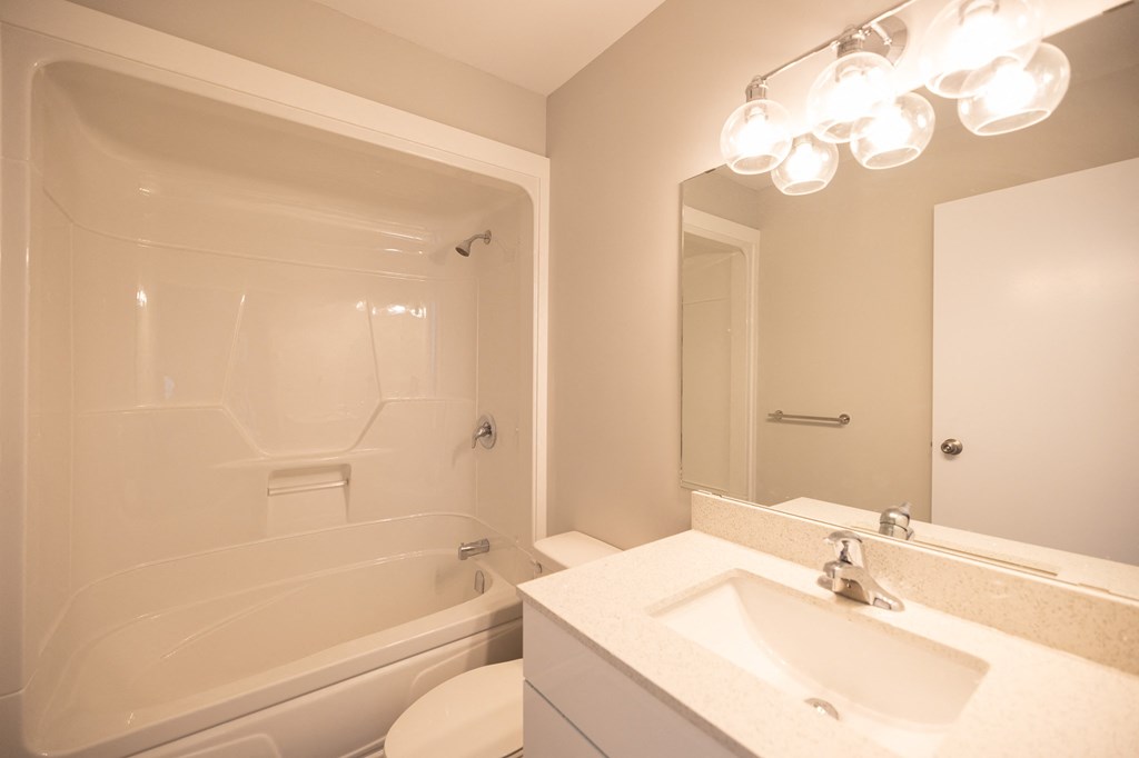 a bathroom with a sink and a tub and a mirror