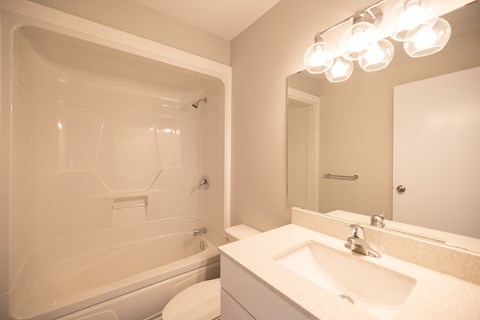 a bathroom with a sink and a tub and a mirror