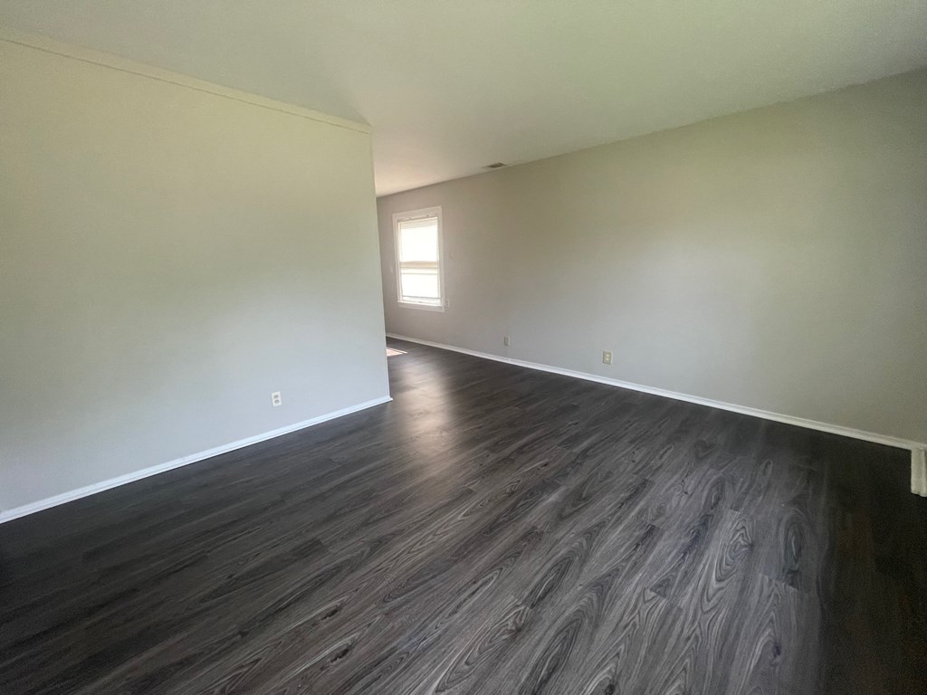 A room with wooden flooring and a window.