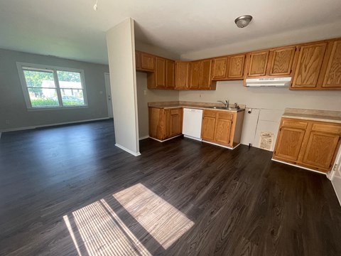 A kitchen with wooden cabinets and a white fridge.
