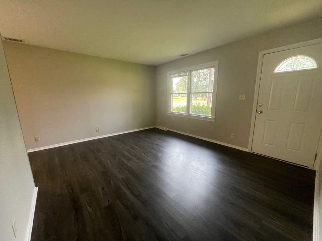 A room with a wooden floor and a white door.