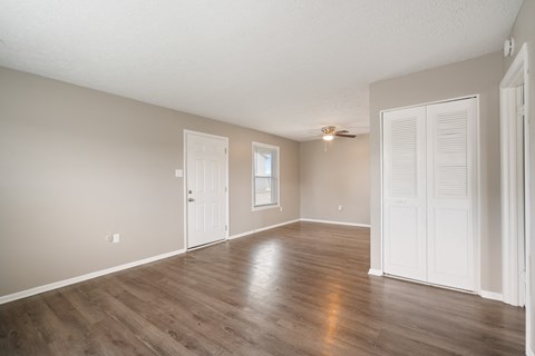 the living room and dining room of an empty house with wooden floors and white doors