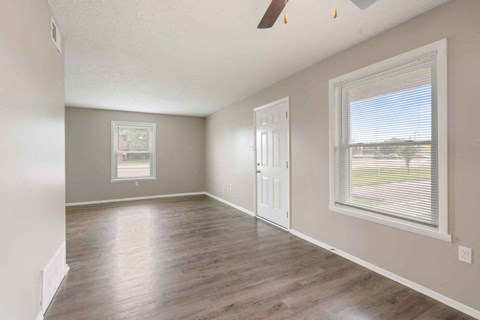 an empty living room with a window and a door